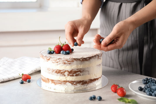 Pastry chef decorating a cake with fruit