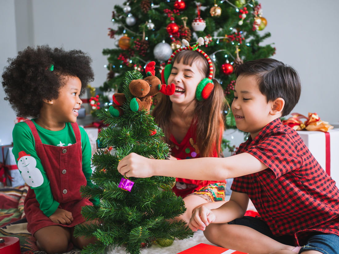 Kids decorating miniature pine tree as a fun Christmas party game 