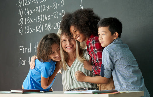 Young kids hugging a teacher to show appreciation