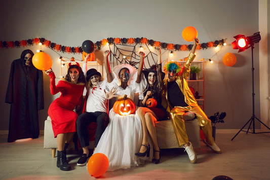 Group of friends having fun at Halloween birthday party while wearing costumes 