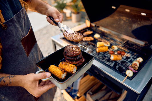 Closeup of man grilling burgers and corn for Labor Day BBQ 