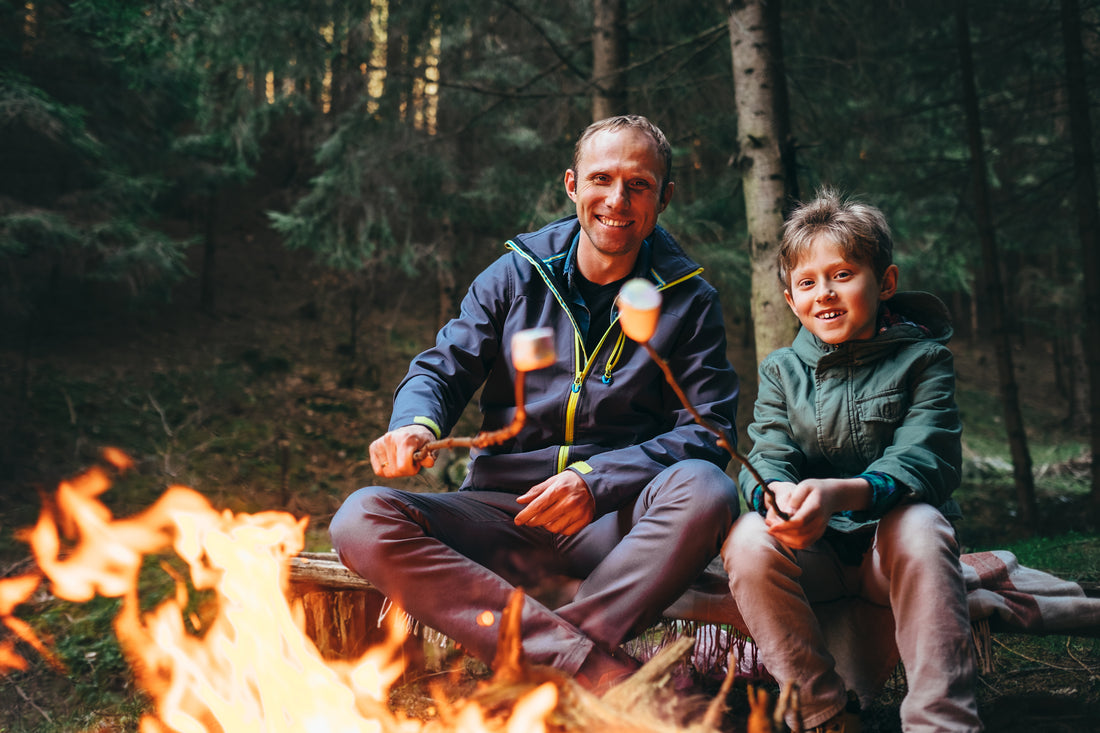 Father and son roasting marshmallows for a camping dessert