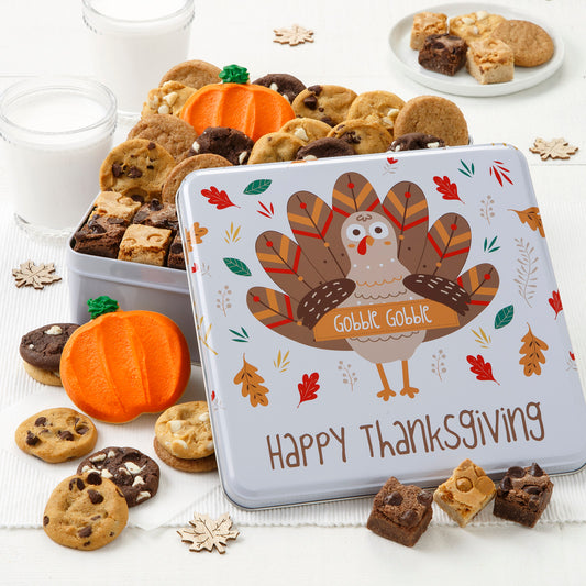 Festive Turkey tin with an assortment of falling leaves. This tin is filled with an assortment of Nibblers®, brownie bites and frosted pumpkin cookies. 