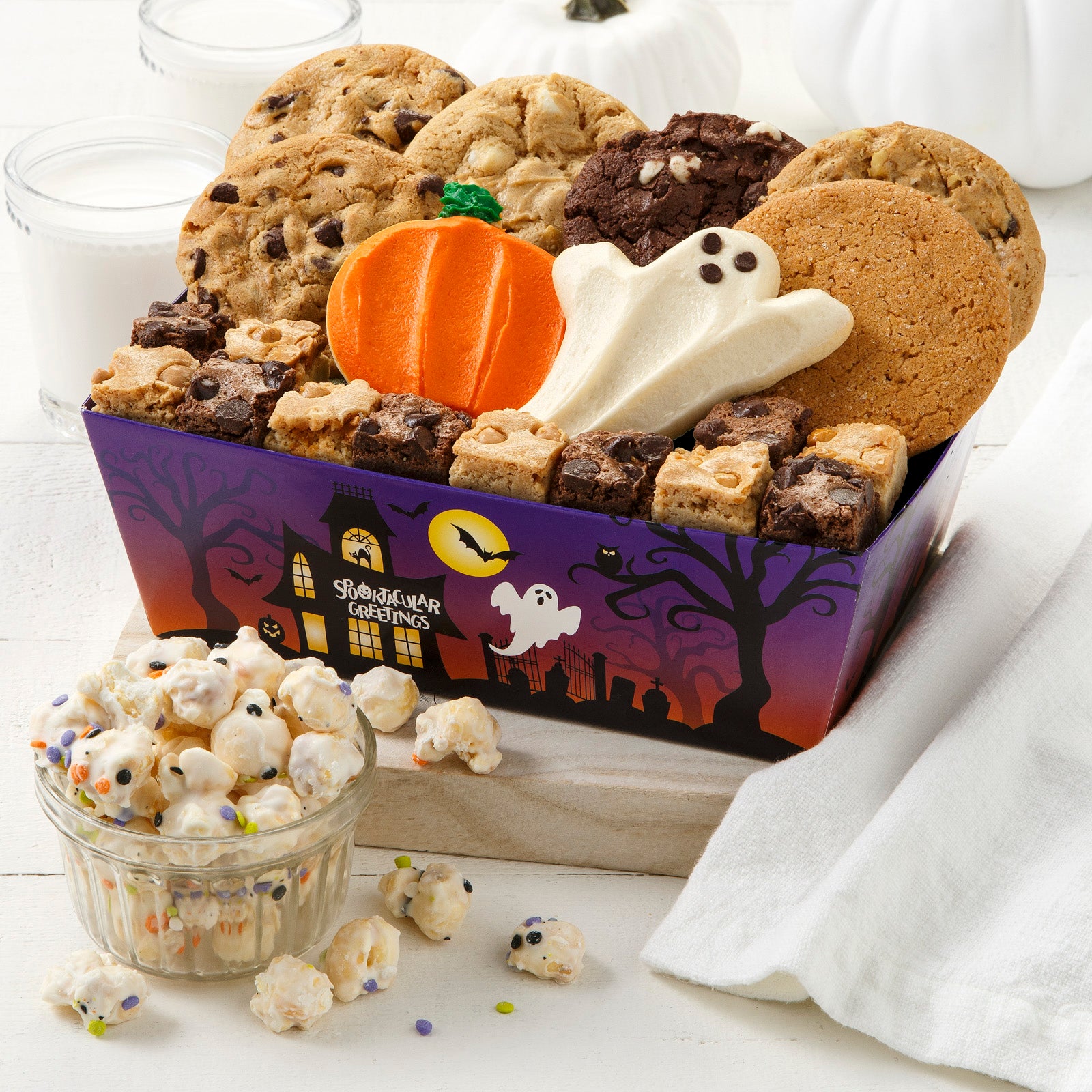 Halloween crate featuring a spooky haunted house, graveyard and ghost. This crate is filled with an assortment of Nibblers®, brownie bites, Halloween popcorn and frosted pumpkin and ghost cookies. 