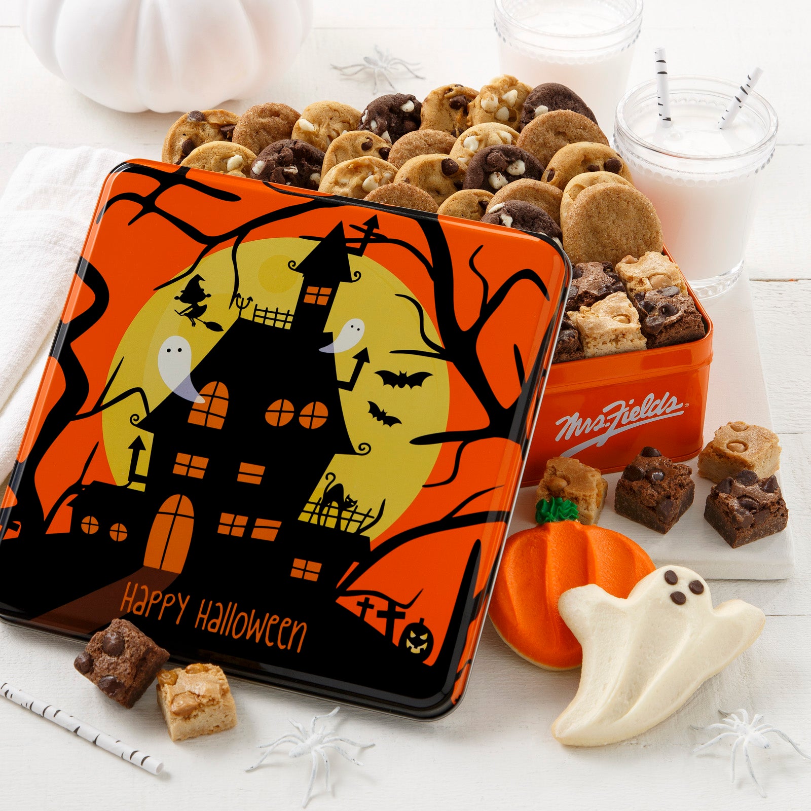 Halloween tin featuring a spooky haunted mansion with ghosts. This tin is filled with an assortment of Nibblers®, brownie bites and frosted pumpkin and ghost cookies.