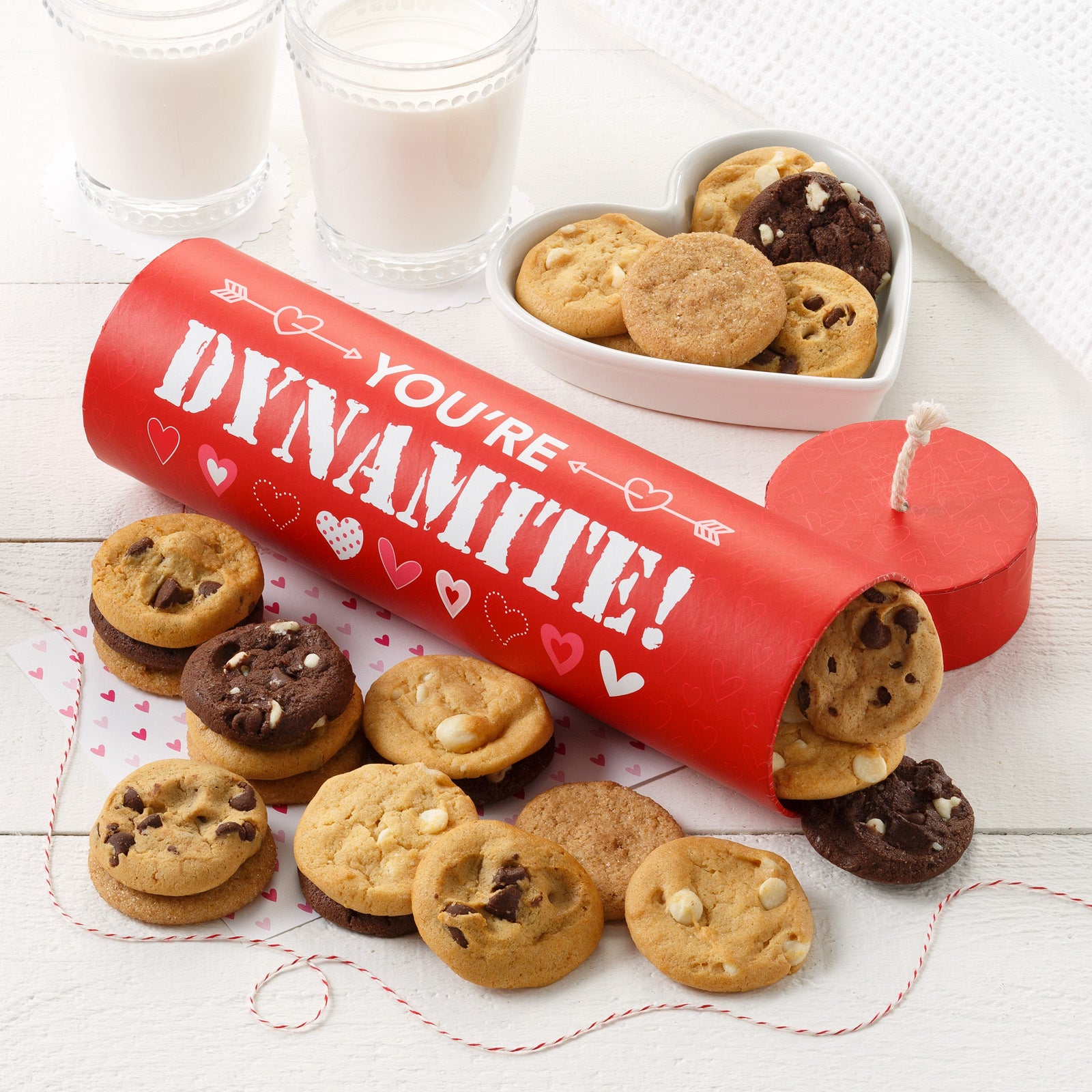 A red cylinder gift box surrounded by an assortment of nibblers.