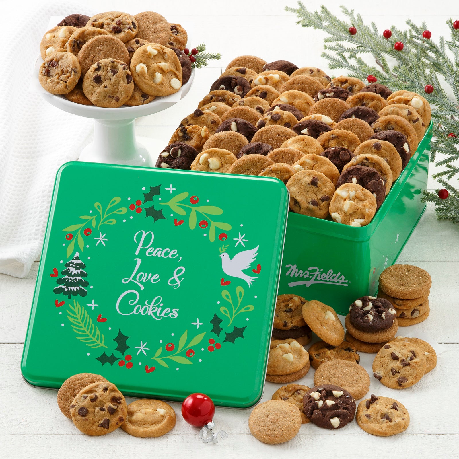 Green Peace, Love, & Cookies decorated with a holiday wreath and filled with an assortment of Nibblers®