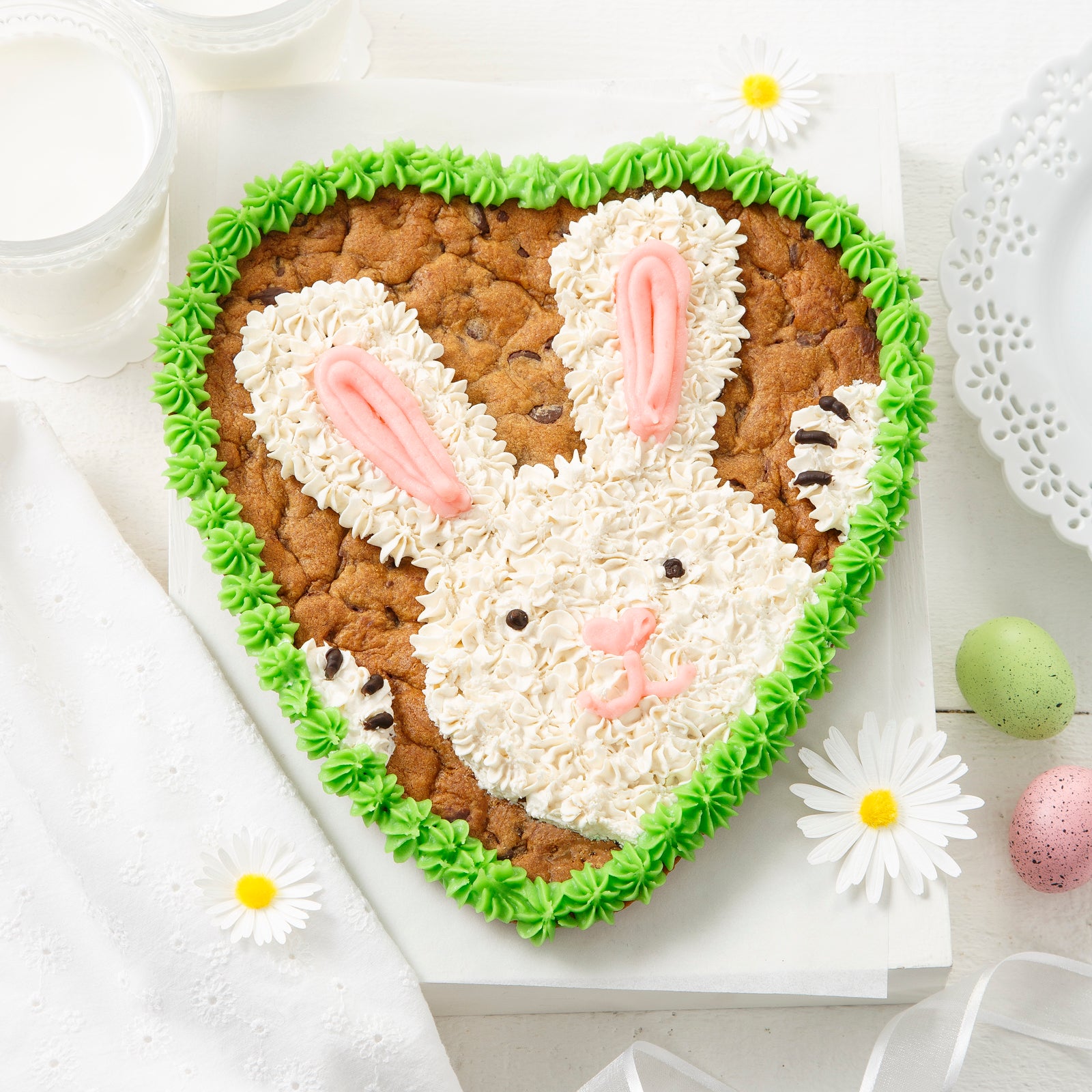 A heart-shaped cookie cake decorated with a frosted bunny