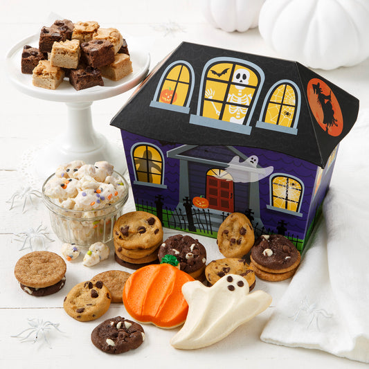 Haunted house box decorated with a fun cast of ghosts and skeletons. This box is filled with an assortment of Nibblers®, brownie bites, Halloween popcorn and frosted pumpkin and ghost cookies.