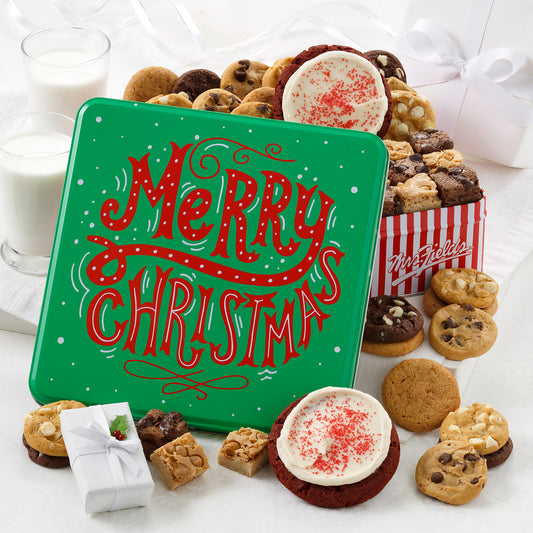 A green Merry Christmas tin with red words and falling snow. The tin comes with 24 Nibblers® bite-sized cookies, 12 brownie bites and 2 frosted holiday wreath cookies.