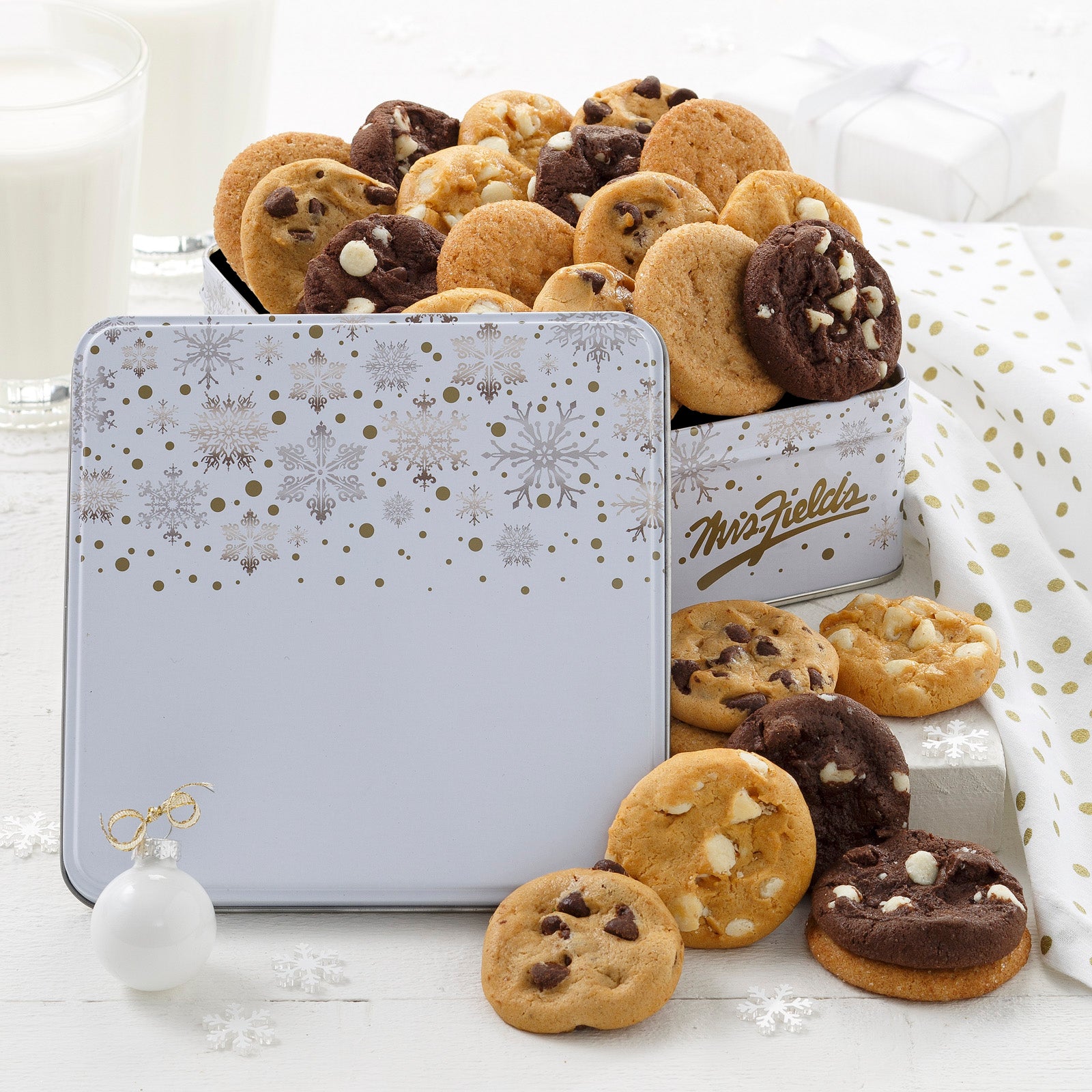 Falling gold and silver snowflakes An outdoor winter scene as decoration on a gift tin that is filled with an assortment of Nibblers®