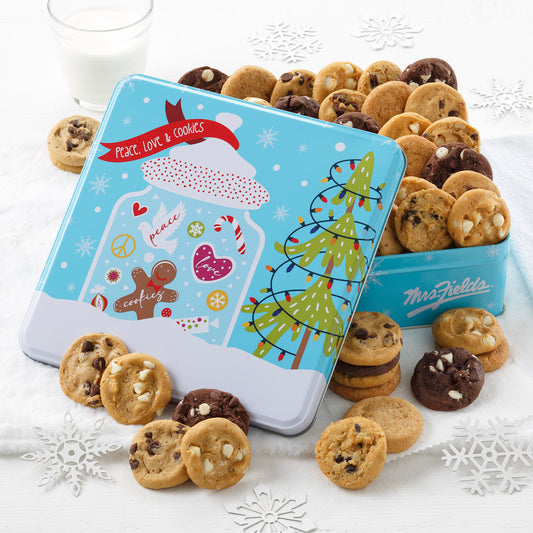 Festive blue tin featuring a holiday cookie man surrounded by holiday candies and a snowy wonderland. This tin includes 48 Nibblers bite sized cookies 