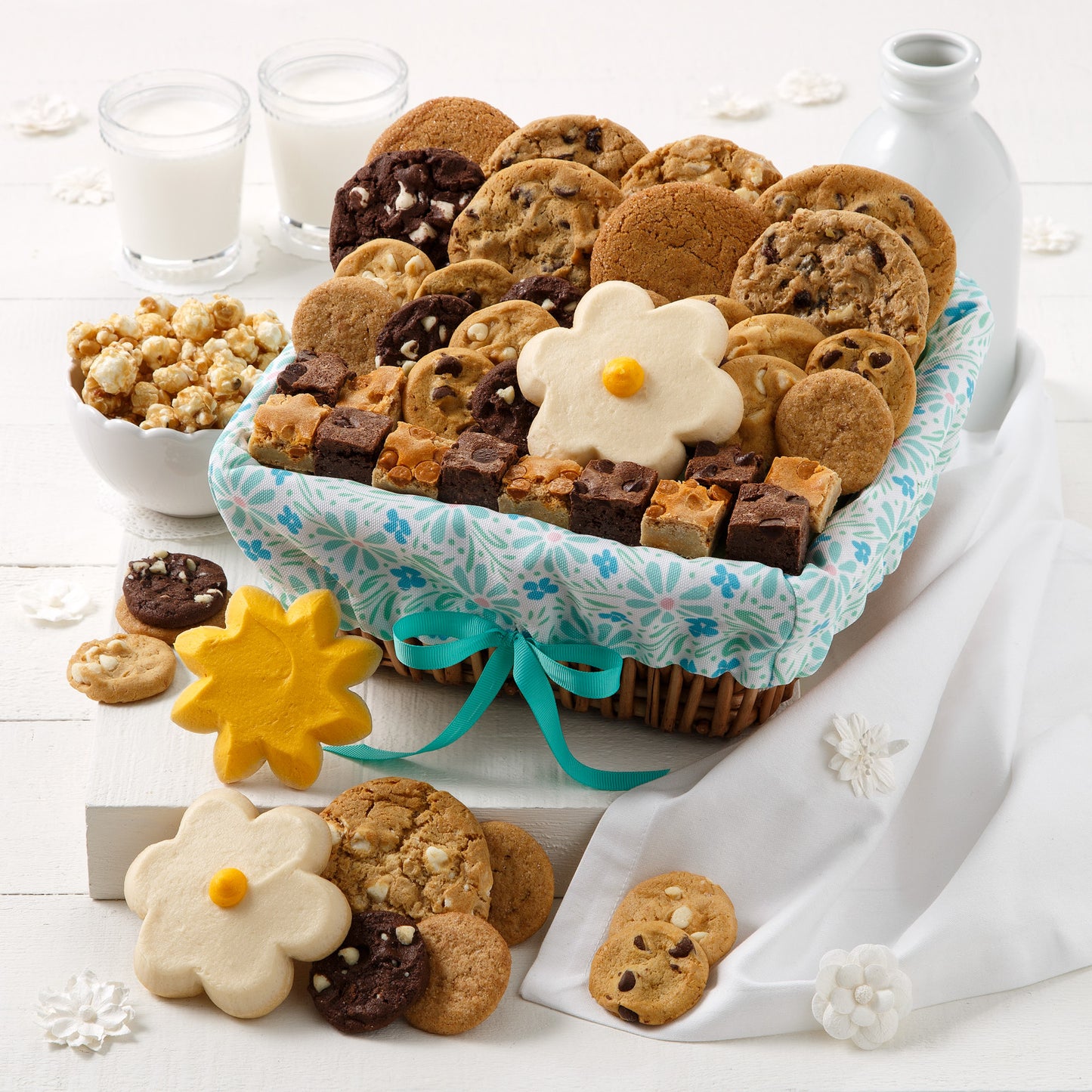 A spring themed gift basket filled with an assortment of original cookies, brownie bites, nibblers, three frosted cookies, and popcorn