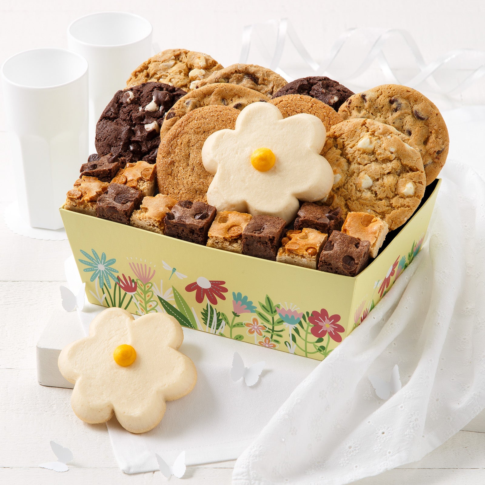 A yellow floral gift crate filled with an assortment of original cookies, brownie bites, and frosted daisy cookies