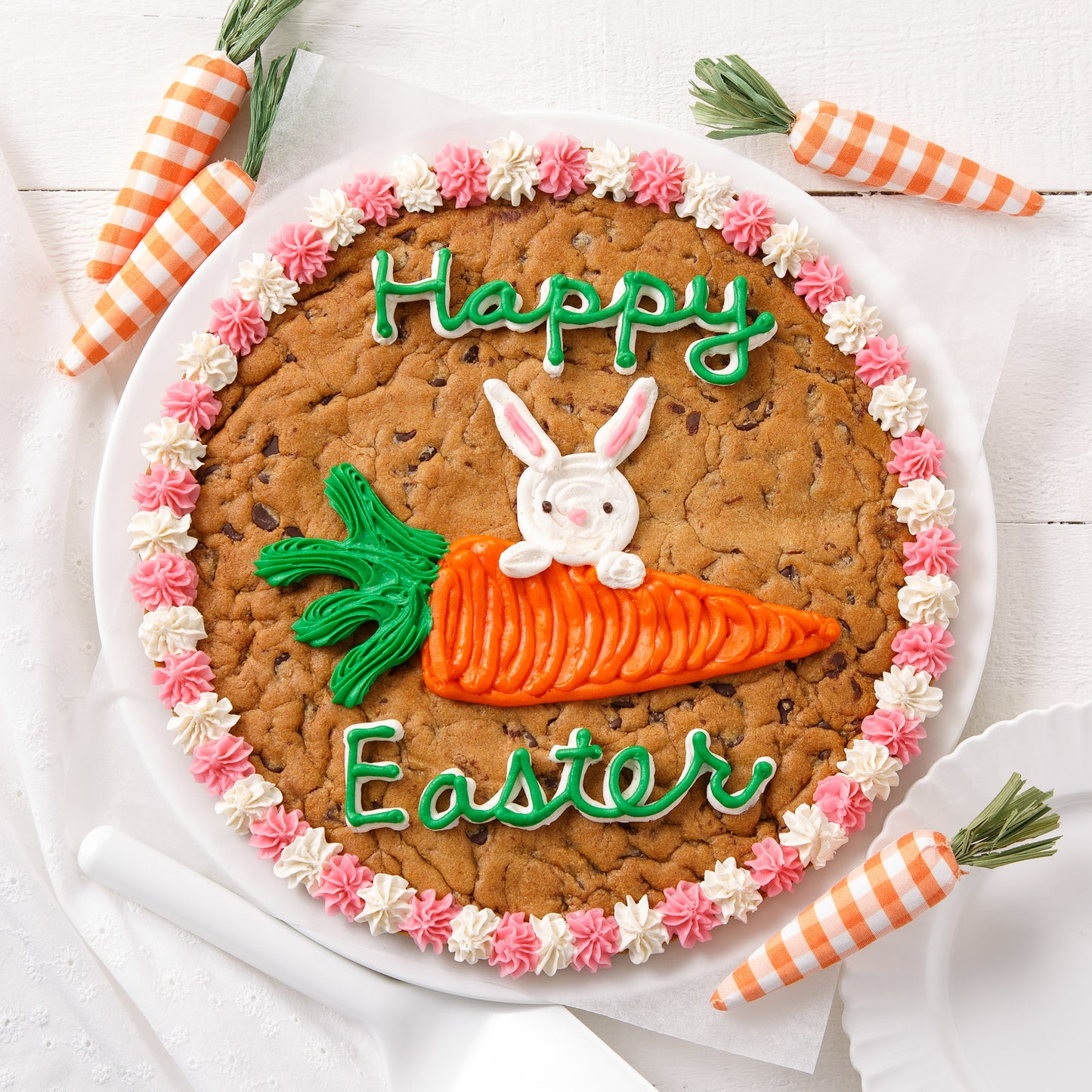 A cookie cake decorated with a Happy Easter sentiment and a bunny with a carrot